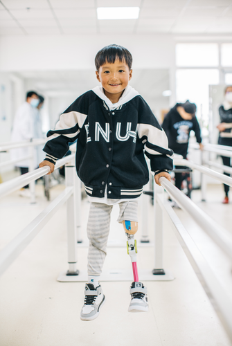 图为中国残疾人福利基金会加油追梦人项目,为残疾儿童适配假肢.